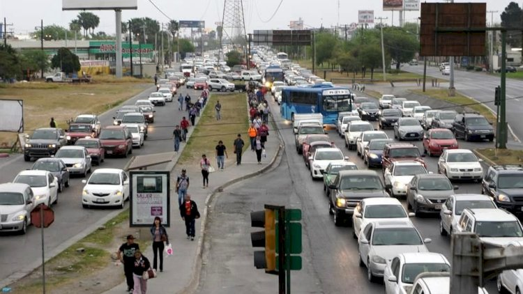 Busy Multi-lane Street with Heavy Traffic on Both Sides and a Central Pedestrian Path Where People Walk Along the Verge and Bus is Visible in the Distance. - Enbroncados