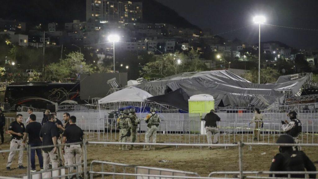 Night Scene at a Fenced Area with Groups of People and Soldiers, a Large Covered Tent Structure in the Background, Bright Floodlights Overhead. - Enbroncados
