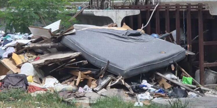 Pile of Trash and a Large Discarded Mattress Wedged Under a Bridge or Overpass. - Enbroncados