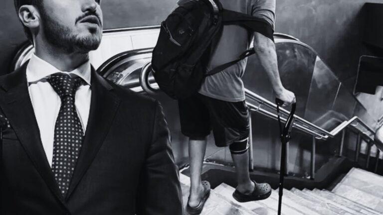 in Grayscale, a Man in a Suit Stands at the Left While Another Person with a Backpack and a Crutch Climbs Down a Stairwell Behind Him. - Enbroncados