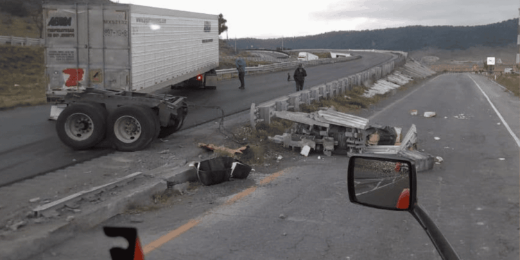 Semi-trailer Obstructing a Curved Highway with Scattered Debris and Damaged Guardrails; Two People Assess the Scene, with a Truck Side Mirror Visible in the Foreground. - Enbroncados